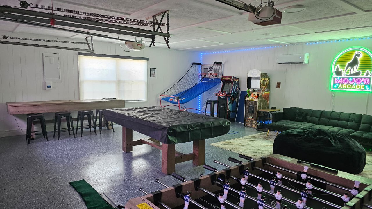 Mojo's Arcade full room with foosball, pool table, and arcade cabinets